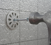Klop metalen spreidnagel in isolatieplug wat een perfecte en duurzame aansluiting gegarandeerd op muur